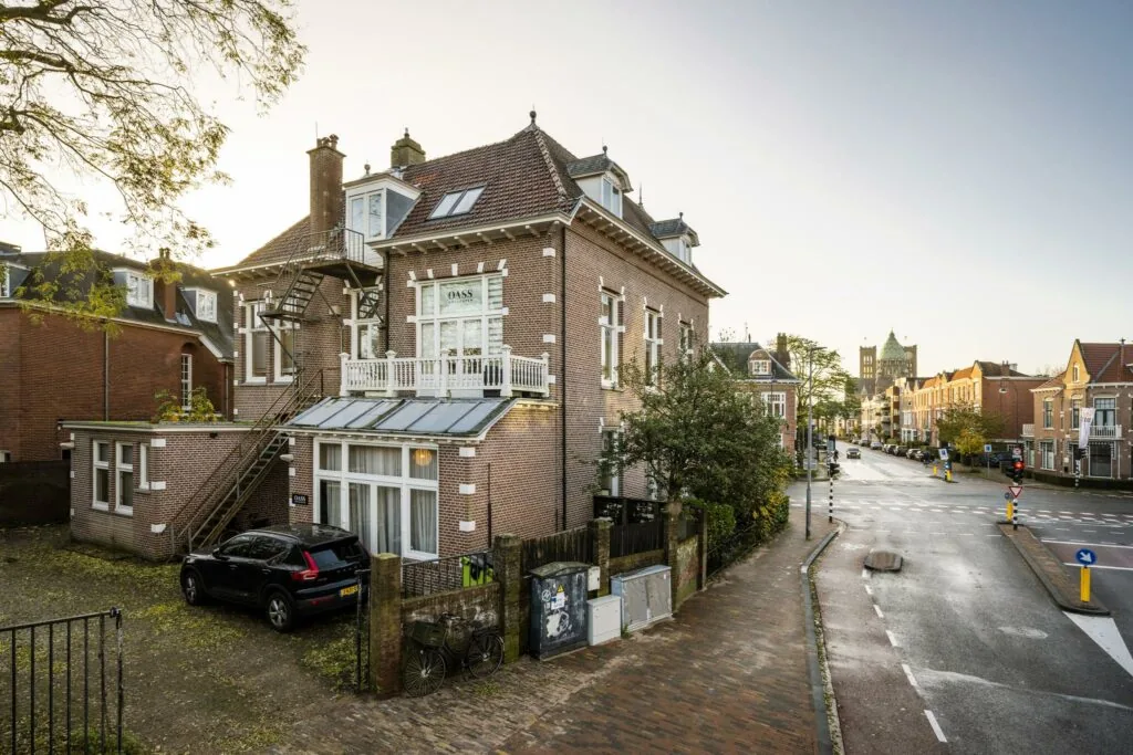 Hoekpand met trapgevel aan de Van Eedenstraat, met geparkeerde auto en zicht op een rustige straat in een historische woonwijk.